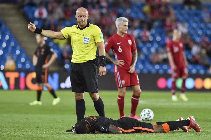 Archivo - 01 September 2021, Norway, Oslo: Netherlands' Georginio Wijnaldum (R) lies on the ground injured in front of Polish referee Szymon Marciniak during the 2022 FIFA World Cup European Qualifying soccer match between Norway and the Netherlands at 