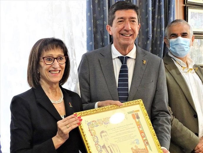 La presidenta de la Casa de Andalucía en Barcelona, Paquita Marín, entrega al vicepresidente Juan Marín una placa.