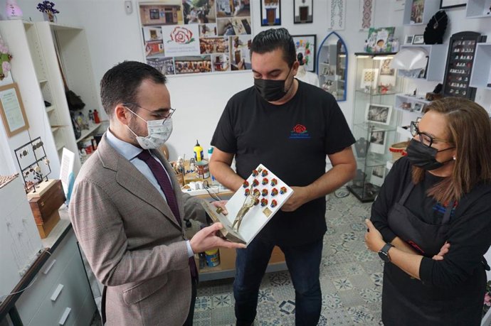 Ángel Herrador (izda.) durante la visita al taller del artesano de Rafael Aguilera (centro).