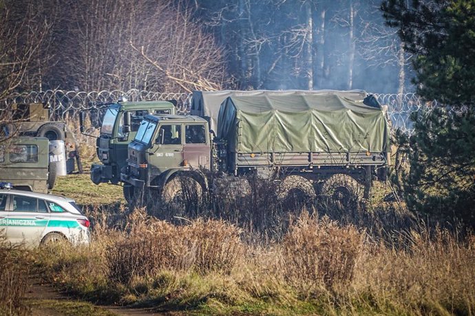 Vehículos del ejército polaco permanecen en la frontera de alambre de espino entre Polonia y Bielorrusia, cerca del paso fronterizo de Kusnica.