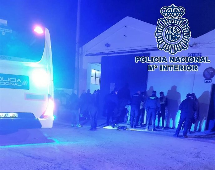 Inmigrantes custodiados por agentes de Policía Nacional y Guardia Civil.