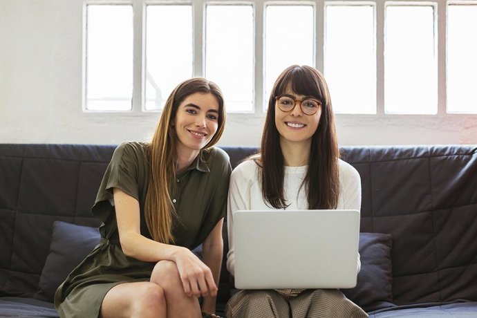 Dos universitarias miran la cámara.