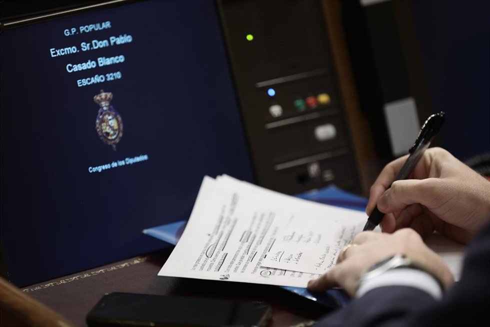 El líder del PP, Pablo Casado, escribe en un papel durante una sesión plenaria en el Congreso de los Diputados, a 10 de noviembre de 2021, en Madrid, (España).