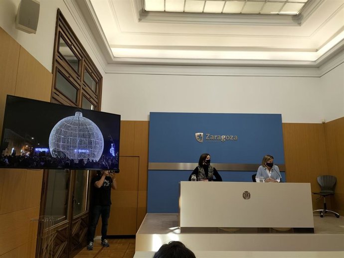 La vicealcaldesa, Sara Fernández, y la consejera municipal Patricia Cavero, muestran una simulación de la gran bola navideña de la plaza del Pilar.