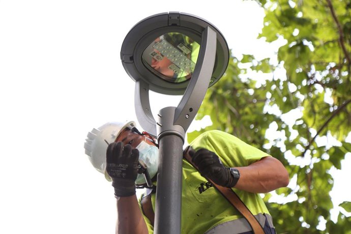 Archivo - Un operario ajusta una de las nuevas farolas LED en Móstoles.