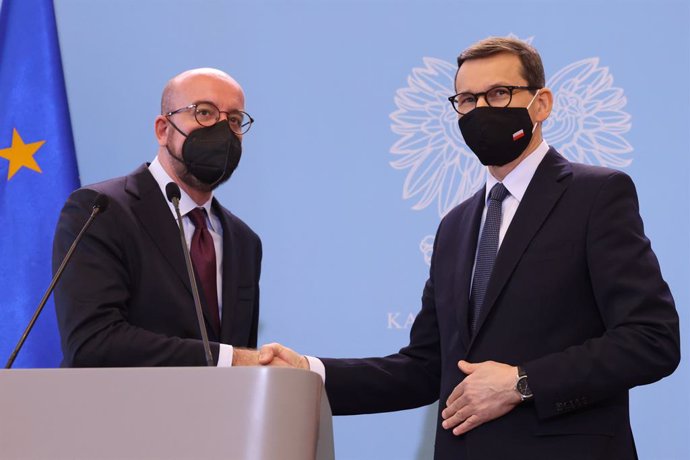 HANDOUT - 10 November 2021, Poland, Warsaw: Polish Prime Minister Mateusz Morawiecki and European Council President Charles Michel shake hands during a joint press conference following their meeting to discuss the migration crisis on the Polish-Belarusi