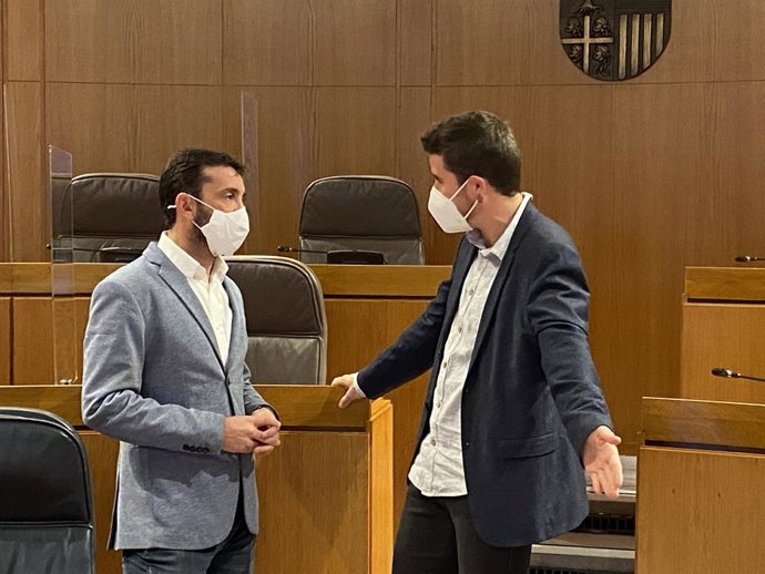 El diputado del PSOE en las Cortes de Aragón, Enrique Pueyo, departe con el portavoz de Podemos, Nacho Escartín.