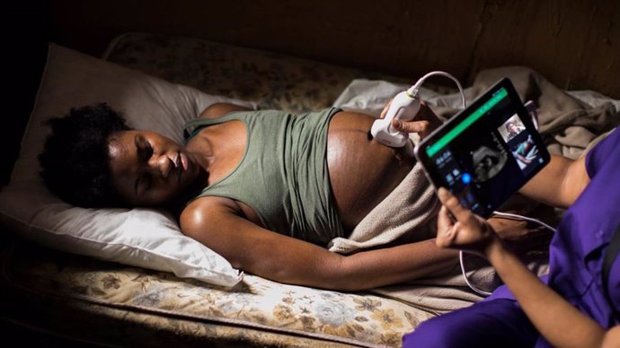 Una partera realiza una ecografía con un dispositivo portátil en África