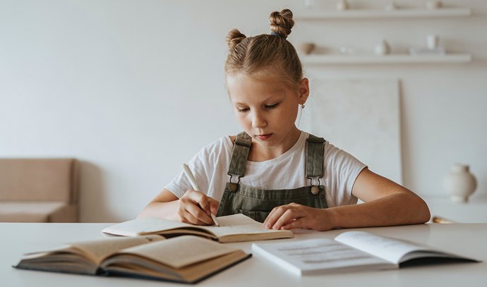 Archivo - Una escolar realiza sus tareas con sus libros de texto (archivo)