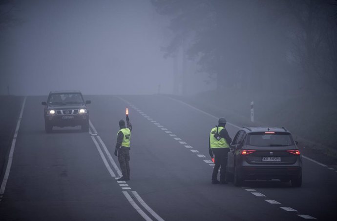 11 November 2021, Poland, Kuznica: Police officers and military police check cars near the Kuznica border crossing on the border between Poland and Belarus. The migration crisis involving refugees trying to enter the European Union via Belarus has escal