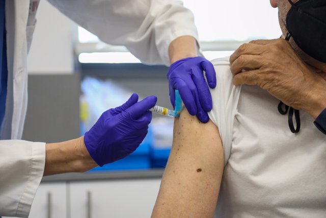 Una persona mayor se vacuna contra la gripe en el centro de Salud Baviera