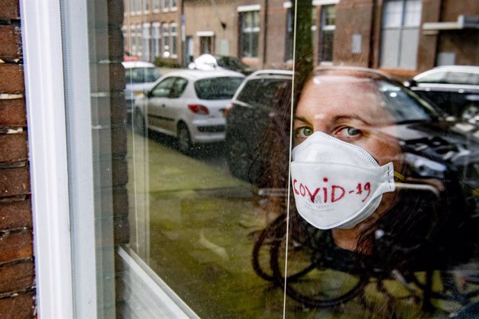 Archivo - 17 March 2020, Netherlands, The Hague: A Coronavirus (covid-19) patient poses for photo looking out from her window at her home as she is being quarantined. Photo: Robin Utrecht/SOPA Images via ZUMA Wire/dpa