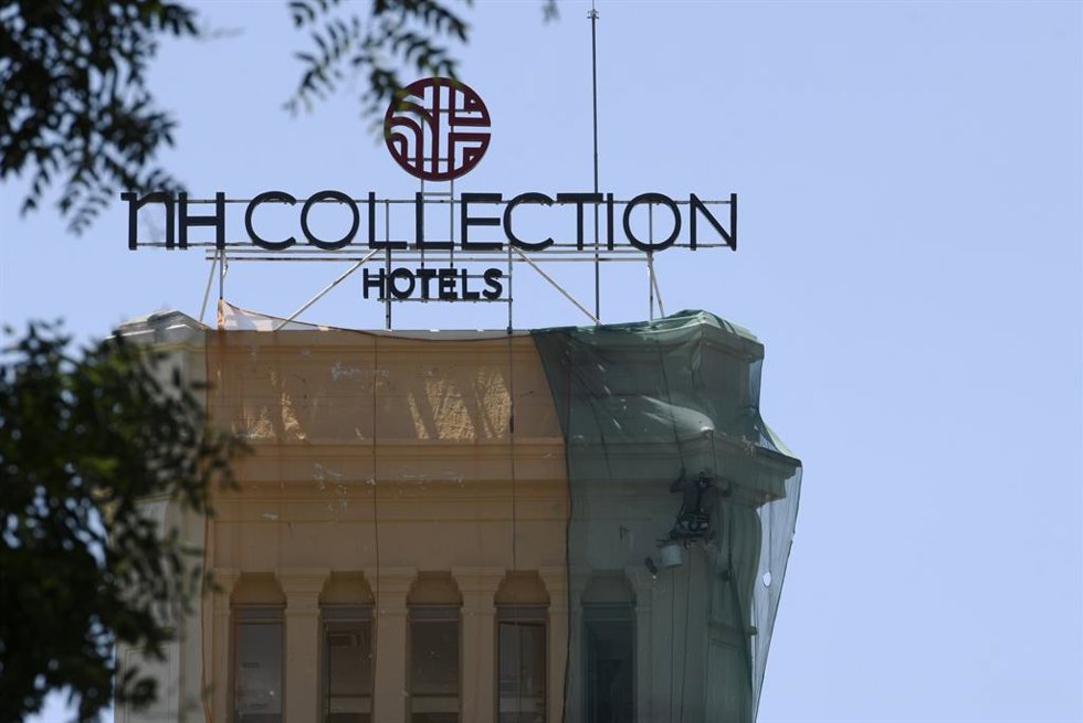 Archivo - Un obrero pinta la fachada del edificio donde se ubica uno de los hoteles NH Collection de la capital.