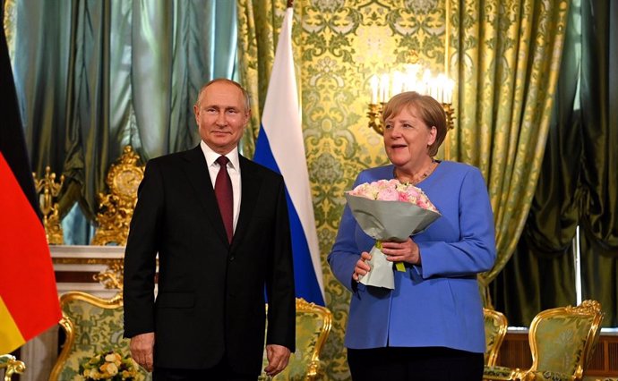 Archivo - HANDOUT - 20 August 2021, Russia, Moscow: German Chancellor Angela Merkel (R)is presented with flowers by Russian President Vladimir Putin during their meeting in the Kremlin. Photo: -/Kremlin/dpa - ATTENTION: editorial use only and only if t
