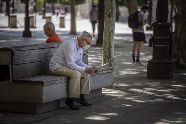 Un hombre con mascarilla lee el periódico durante el quinto día de la fase 2 en Sevilla (Andalucía, España), a 29 de mayo de 2020.