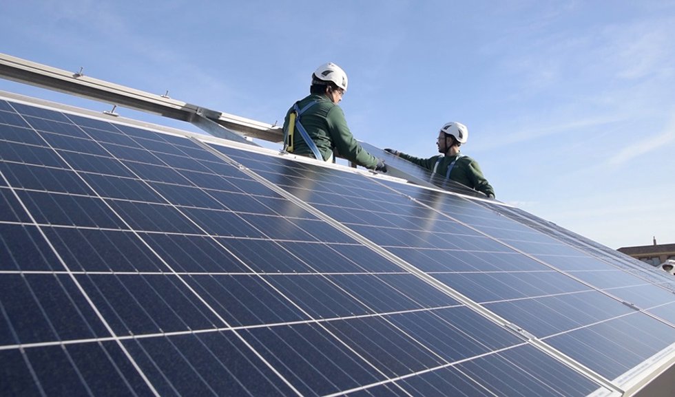 Archivo - Dos operarios instalan placas solares