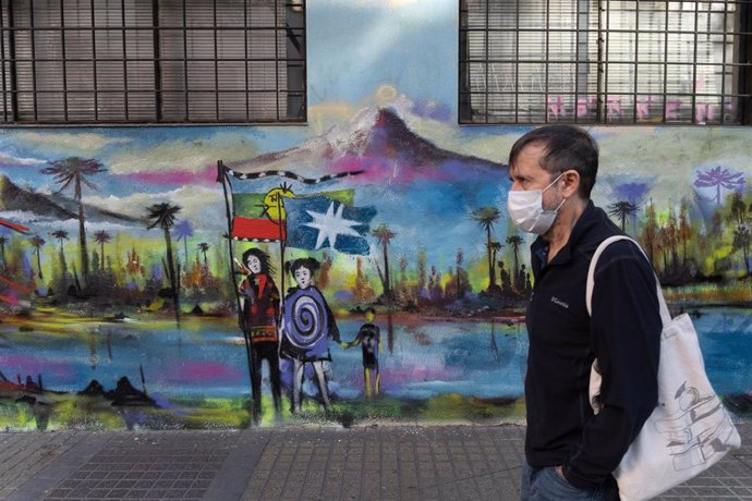November 4, 2021, Santiago, Metropolitana, Chile: A man with a face mask walks in front of a mural painted in support of the Mapuches.