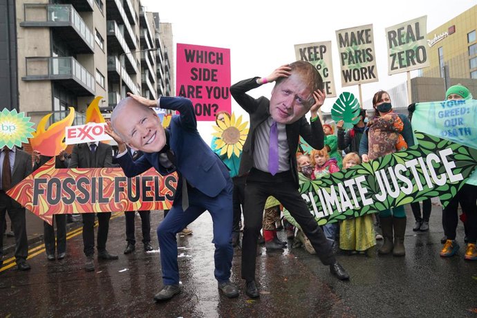 12 November 2021, United Kingdom, Glasgow: Climate Justice Activists dressed as US President Joe Biden and Britain's Prime Minister Boris Johnson take part in a protest asking delegates as they make final decisions, "Are You With Us Or With Fossil Fuels