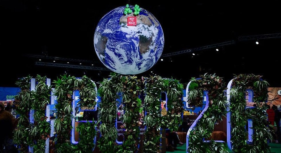 Greenpeace activists raise a banner reading NOT FOR SALE against the iconic giant globe at the centre of the COP26 conference hall in Glasgow, as talks enter their final hours.