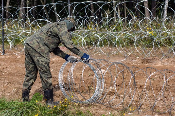 Archivo - September 1, 2021, Wojnowce, Usnarz Gorny, Minkowce, Podlaskie, Poland: Polish soldier seen building a razor wire fence along the border with Belarus close to the village of Minkowce..The Polish government is introduce a State of Emergency on 