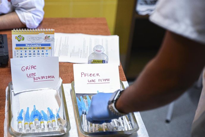 Dos bandejas, con vacunas contra la gripe y con terceras dosis de la vacuna contra el Covid-19