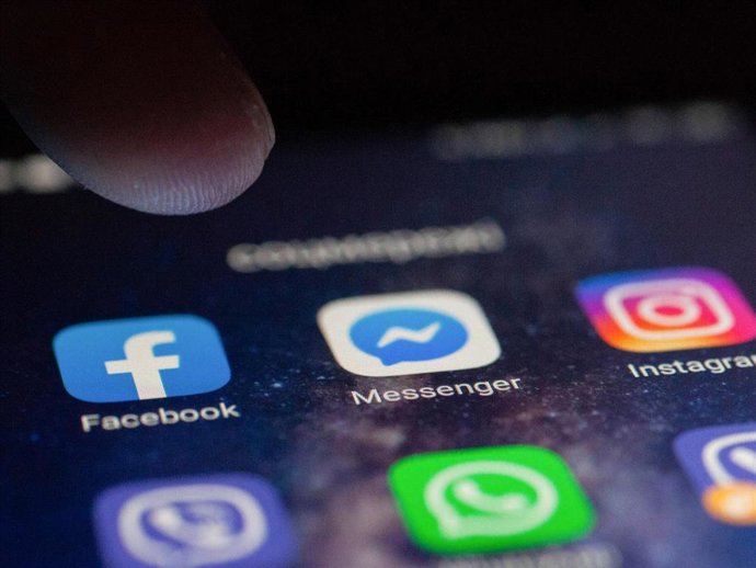 In this photo illustration, a finger touching the Facebook application on a smartphone screen.