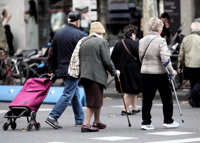 Archivo - Varias personas de la tercera edad cruzan un paso para peatones 
