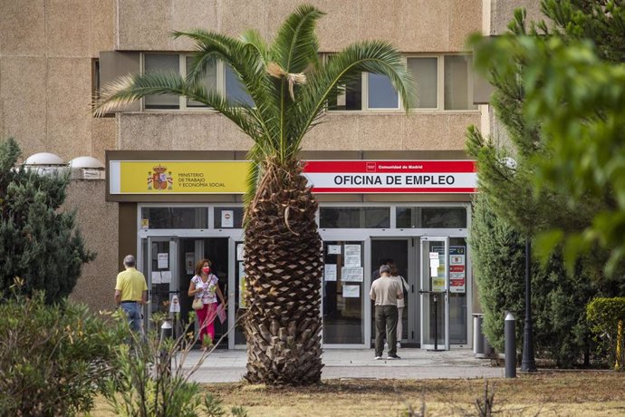 Archivo - Varias personas en la puerta de una oficina del SEPE 