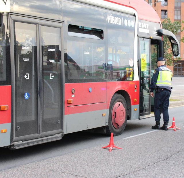 Un agente al lado de un autobús en imagen de archivo