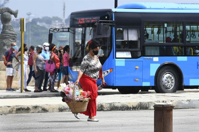 Archivo - Una mujer con mascarilla pasea por La Habana