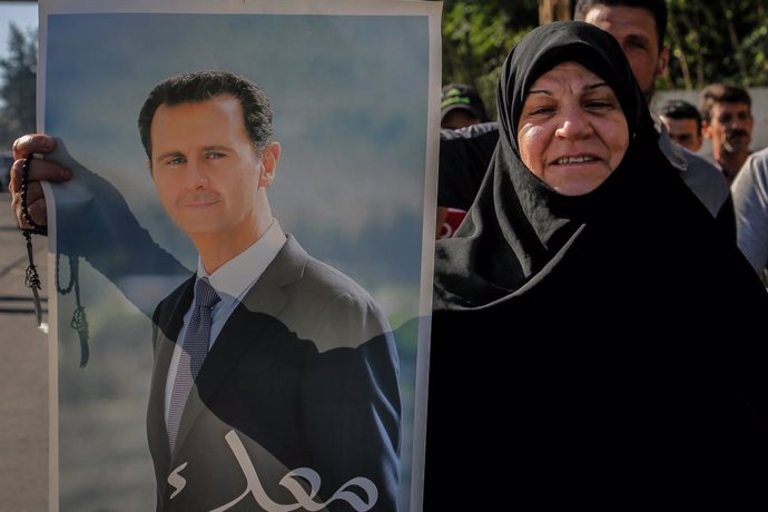Archivo - 20 May 2021, Lebanon, Baabda: A Syrian national holds a picture of Syrian President Bashar al-Assad while heading to cast her vote during the first stage of the Syrian Presidential election at the Syrian Embassy. Photo: Marwan Naamani/dpa