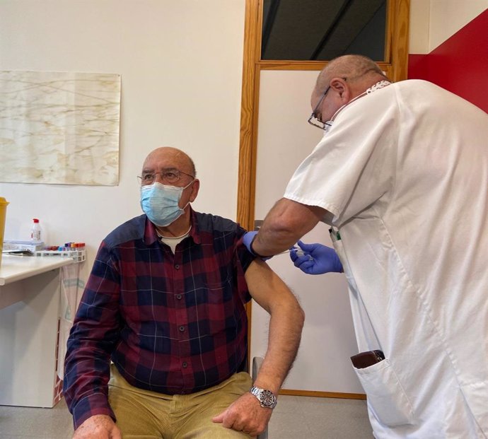 Un hombre recibe una vacuna en un centro de salud.