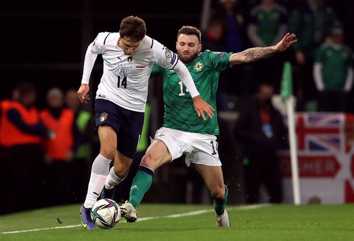 15 November 2021, United Kingdom, Belfast: Northern Ireland's Stuart Dallas and Italy's Federico Chiesa (L) battle for the ball during the 2022 FIFA World Cup European qualifiers Group C soccer match between Northern Ireland and Italy at Windsor Park St