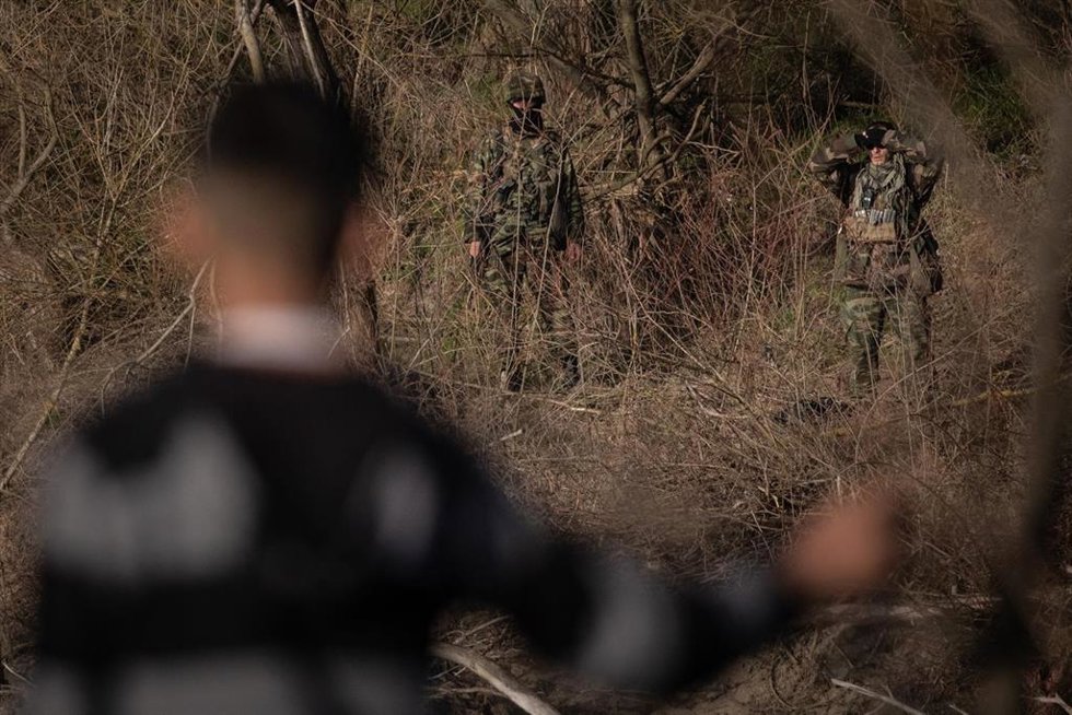 Archivo - Un migrante observa desde la costa turca mientras los soldados griegos patrullan el borde del río Evros el 3 de marzo de 2020 en Edirne, Turquía.