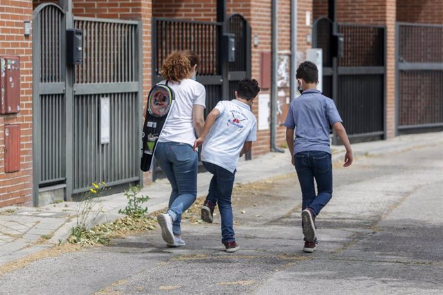 Archivo - Isaac (centro) camina por una calle junto a su madre, Mónica, y su hermano, Gabriel, durante la franja horaria de salida permitida para los niños de hasta 14 años durante la fase 0 del estado de alarma, en Madrid (España) a 7 de mayo de 2020.