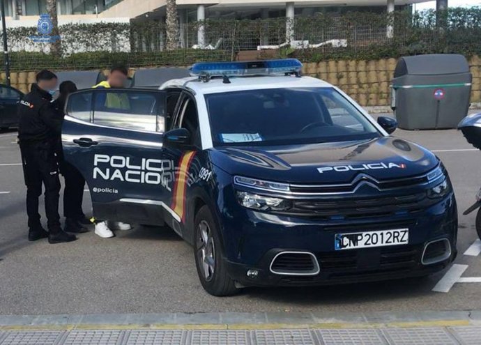 Agentes introducen al arrestado en un vehículo policial.