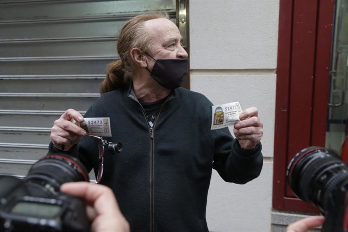 Archivo - Uno de los agraciados sujeta dos décimos premiados en la administración de lotería situada en la Calle Comercio, 21, en la que se ha repartido parte del número 52472 correspondiente al Tercer Premio del Sorteo Extraordinario de Lotería de Navi