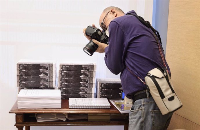 Un fotografía realiza una fotografía a varios tomos de las enmiendas presentadas en una Comisión de Presupuestos, a 16 de noviembre de 2021, en Madrid