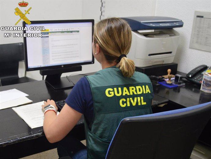 Archivo - Una agente de la Guardia Civil con un ordenador