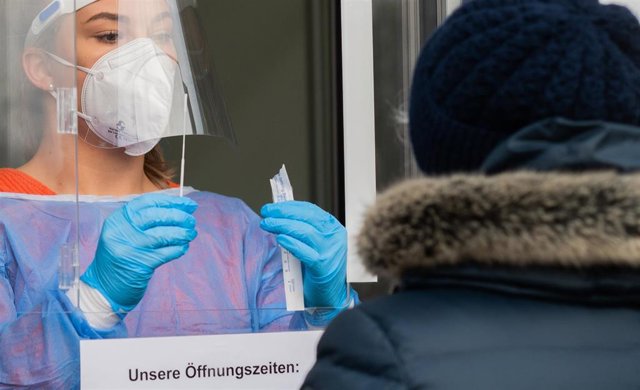 Un sanitario toma una muestra de un paciente en el centro de pruebas de Corona Hannover-Laatzen, en la región de Hannover, 