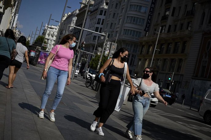 Archivo - Tres turistas caminan por la Gran Vía, en Madrid (España). 
