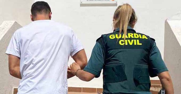 Una agente de la Guardia Civil junto al detenido.