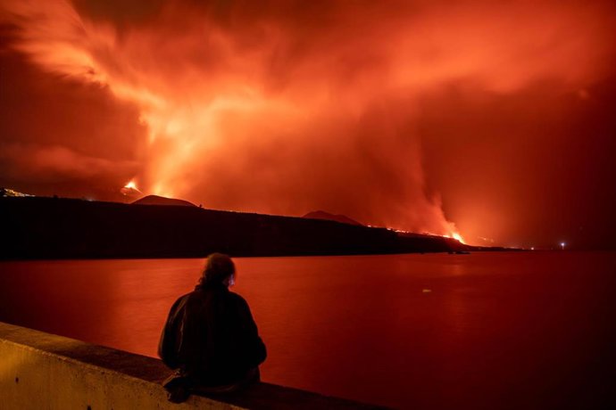 Una persona observa la lava y piroclastos a su llegada a la playa de los Guirres