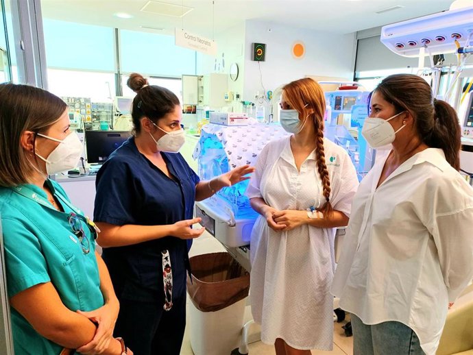 Dos profesionales sanitarias junto a dos madres de bebés prematuros en el Hospital Quirónsalud Málaga
