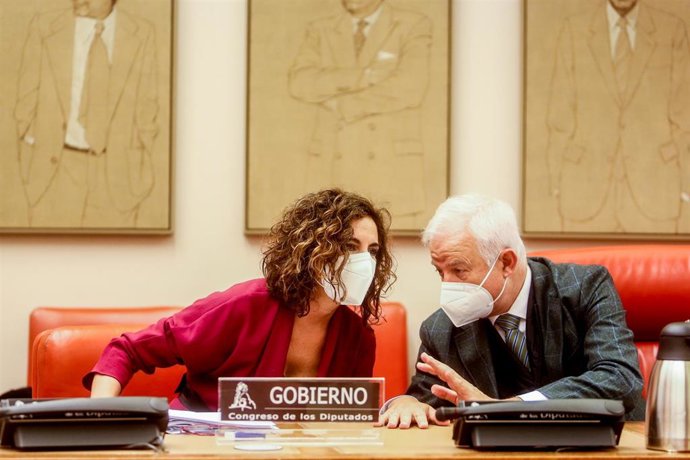 La ministra de Hacienda y Función Pública, María Jesús Montero Cuadrado, conversa con el presidente de la Comisión de Hacienda y Función Pública, Eloy Suárez Lamata, en una Comisión de Hacienda, en el Congreso de los Diputados.