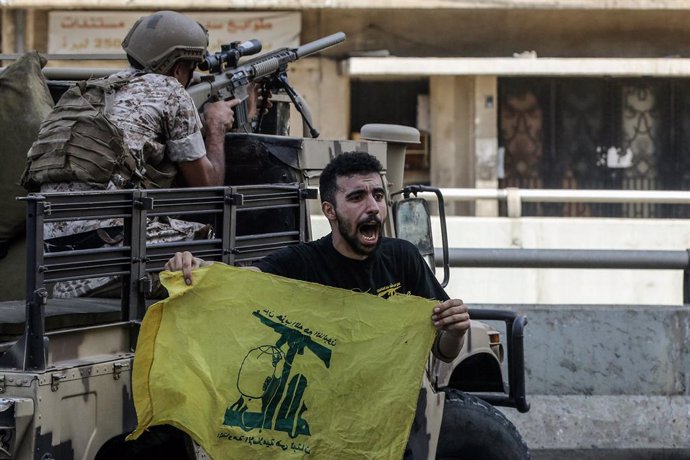Archivo - Un hombre en Líbano con una bandera de Hezbolá