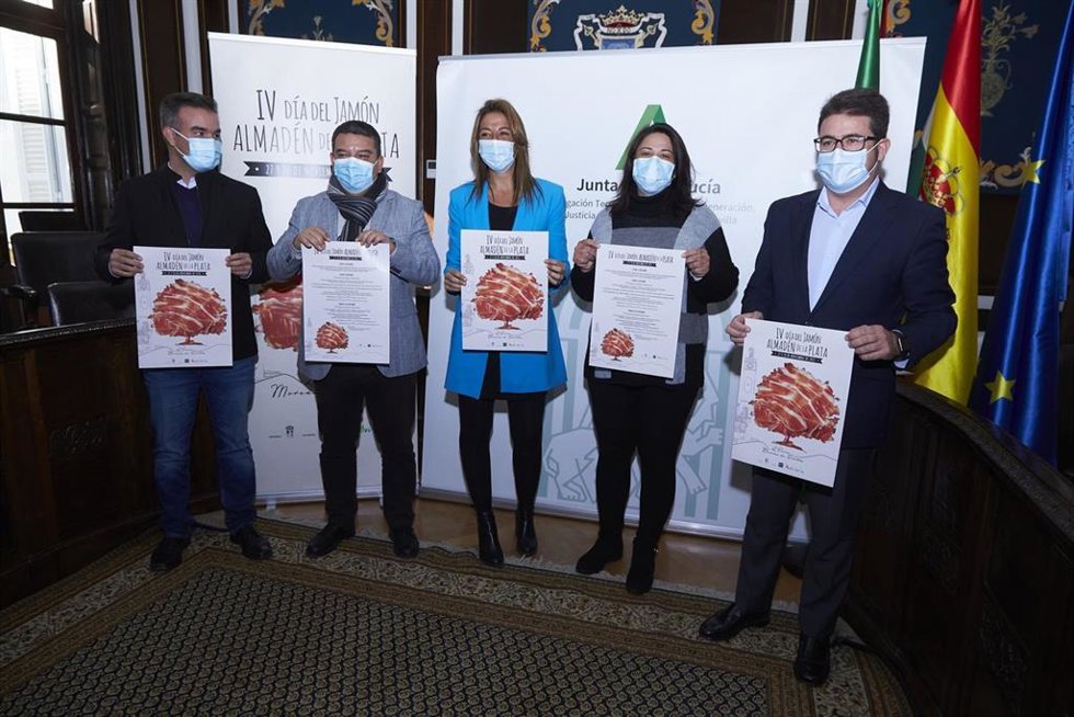 La delegada territorial de Turismo, Rosa Hernández, con el alcalde de Almadén de la Plata, José Carlos Raigosa, presentando el cartel y las actividades del IV Día del Jamón de Almadén de la Plata.