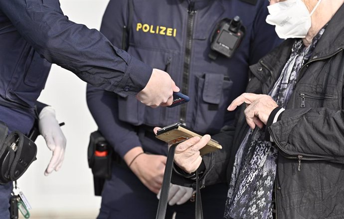 16 November 2021, Austria, Voesendorf: A policeman checks the covid passport of a citizen amid lockdown imposed by the authorities on unvaccinated people. Photo: Hans Punz/APA/dpa
