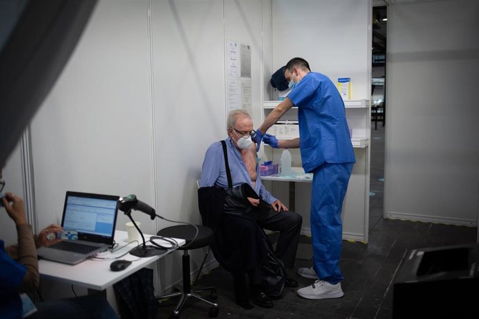 Archivo - Un sanitario vacuna a un hombre en el circuito de vacunación de Fira de Barcelona.