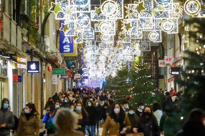 Archivo - Varias personas pasean por calles comerciales en Navidad  